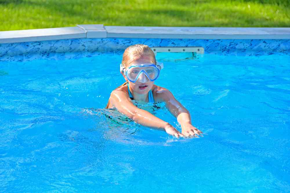 Kind schwimmt im oberirdischen Pool